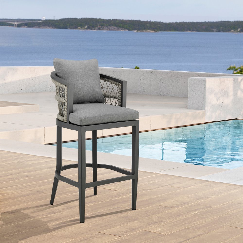 40" Gray Metal Outdoor Bar Height chair with Footrest shown outdoors on a patio.