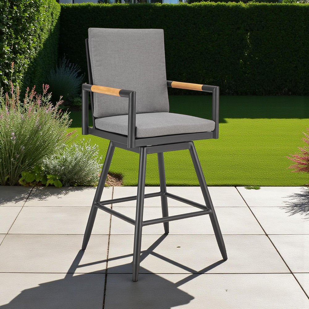 48" Dark Gray Metal Swivel Outdoor Bar Height chair with Footrest shown outdoors on a patio with greenery in charcoal metal.