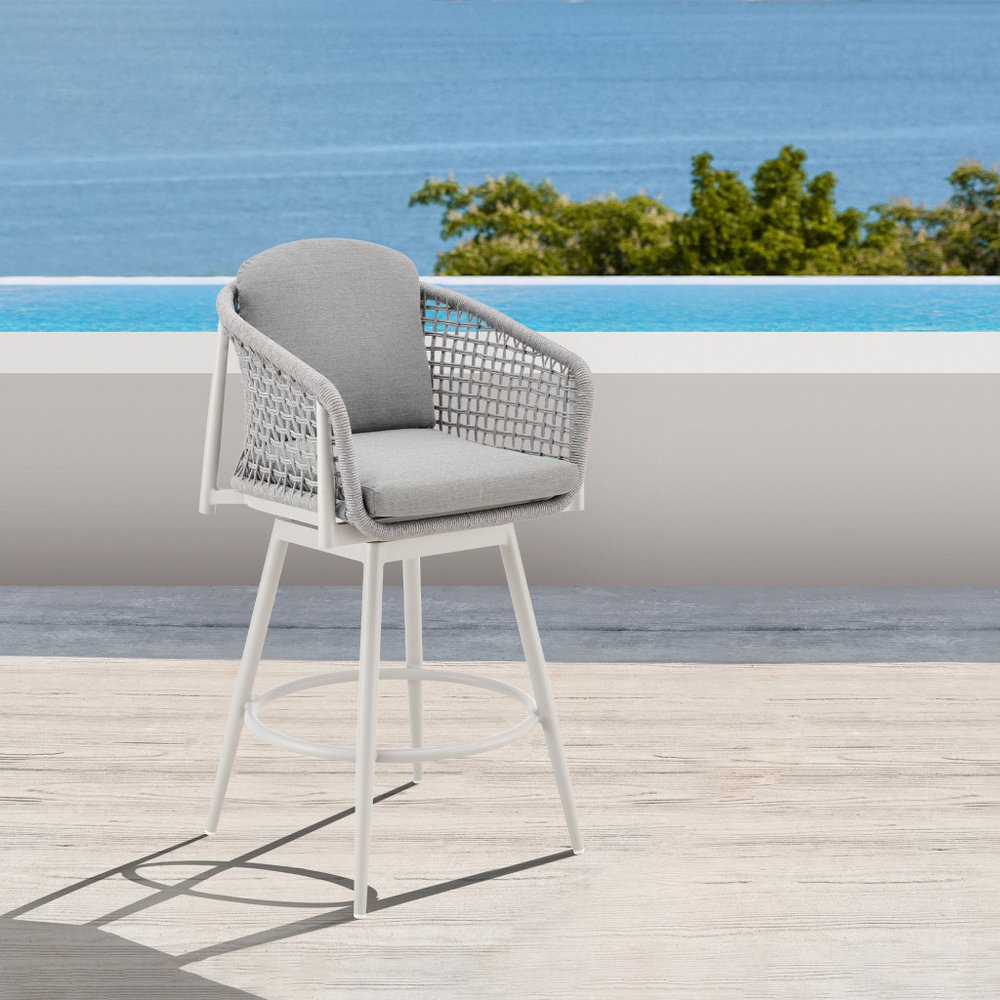 40" Light Gray Metal Swivel Outdoor Counter Height Bar chair with Footrest shown outdoors on a patio.