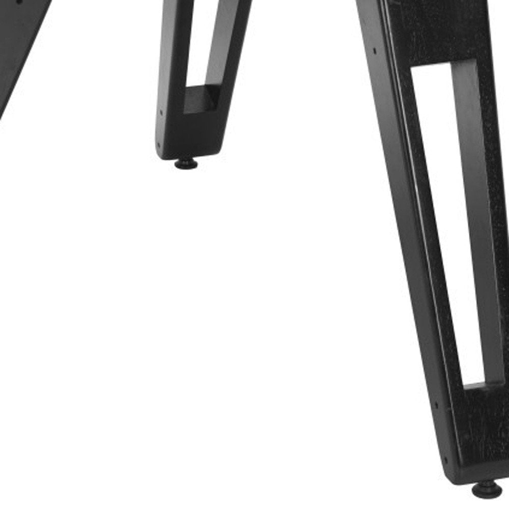 Close-up of black wooden table legs with cutouts against a white background.