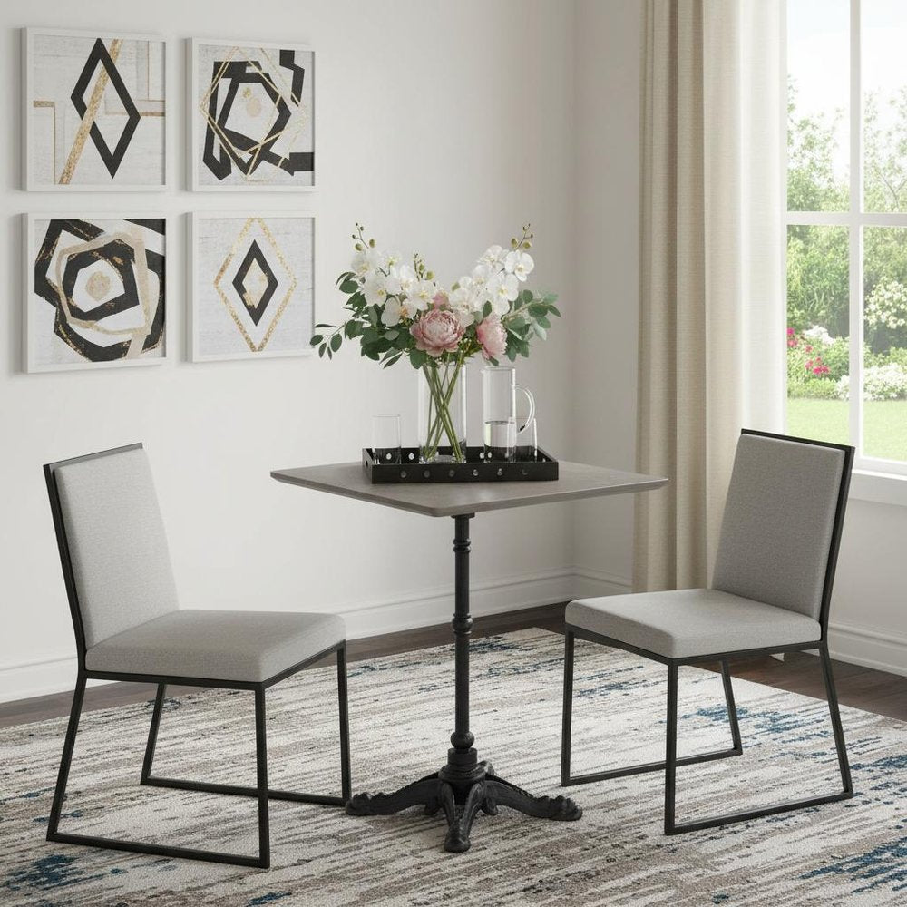 24" Gray and Black Wood And Aluminum Indoor Outdoor Pedestal Base Round Top Dining Table styled in a furnished interior with a light gray wall on a tiled floor.