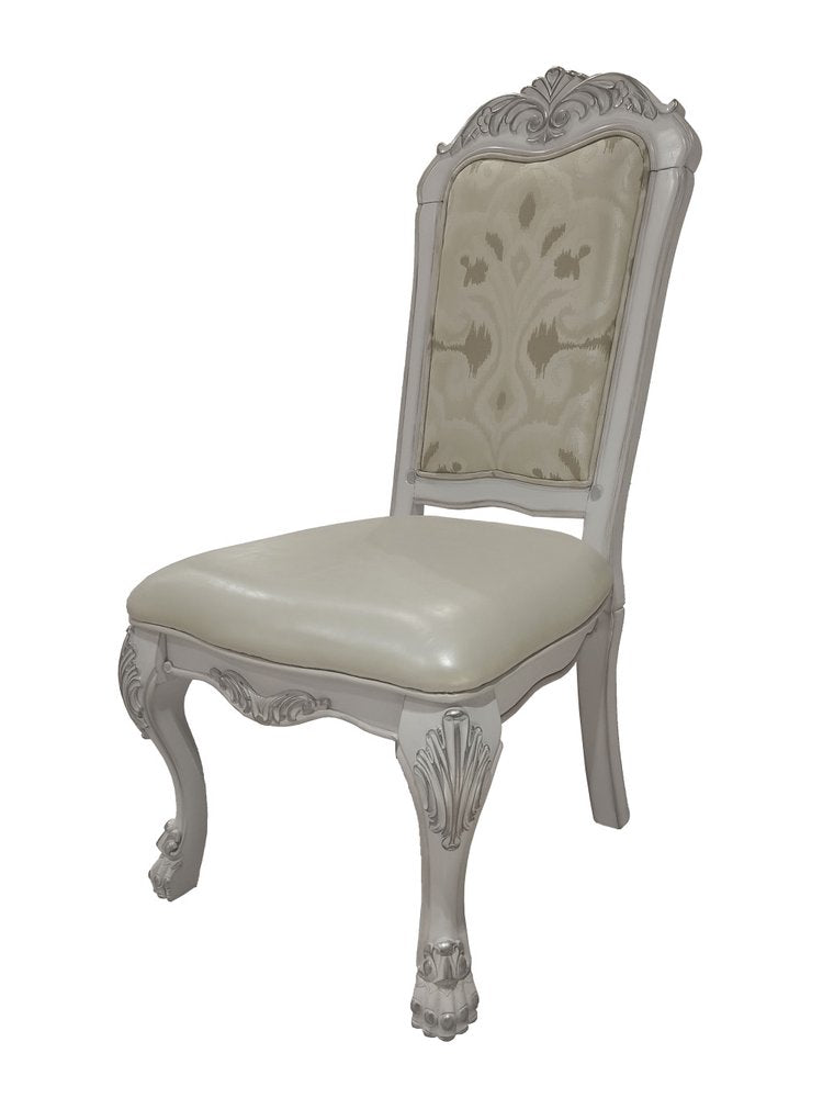 White tufted faux leather dining chair with ornate carved details on a white background.