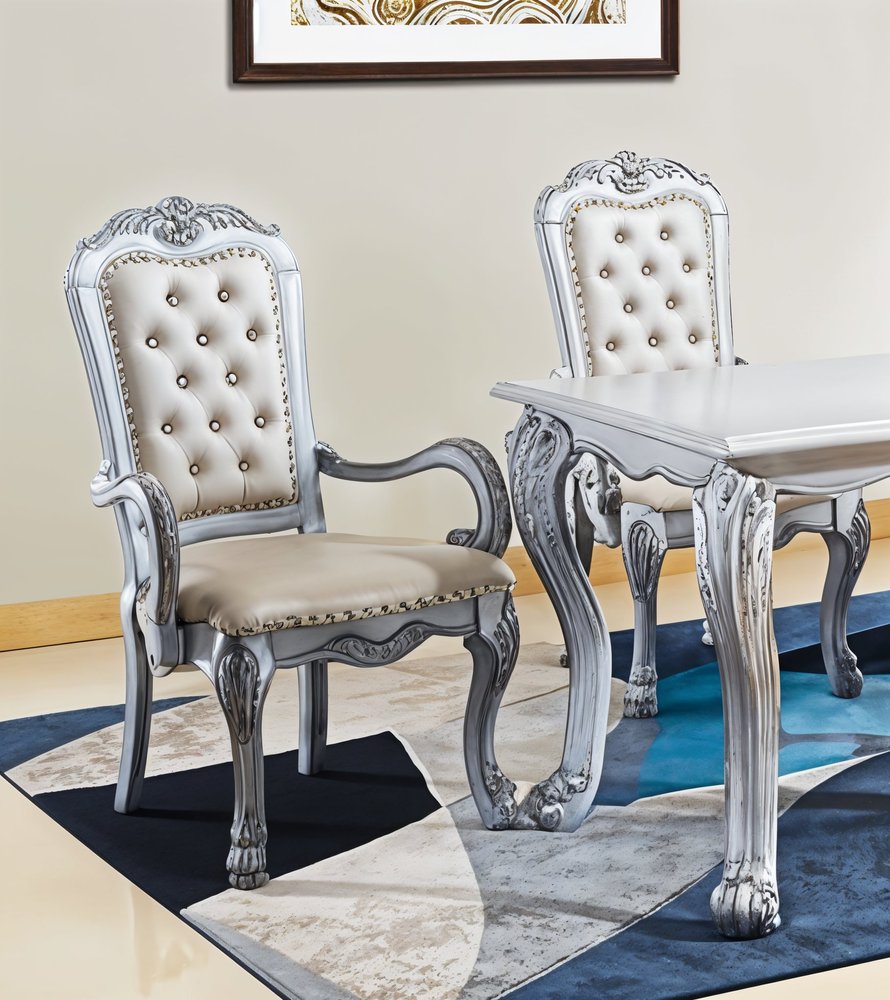 Set of Two Tufted White Upholstered Faux Leather And Wood Dining Arm Chairs in a home interior