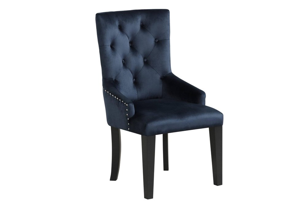 Tufted dark blue velvet dining chair with silver nailhead trim and black wooden legs on a white background.