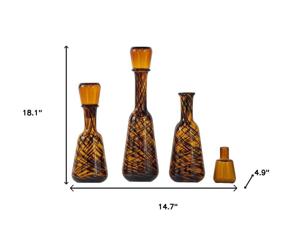 Set of Three Amber Abstract Swirl Glass Decorative Bottles With Stoppers on a white background