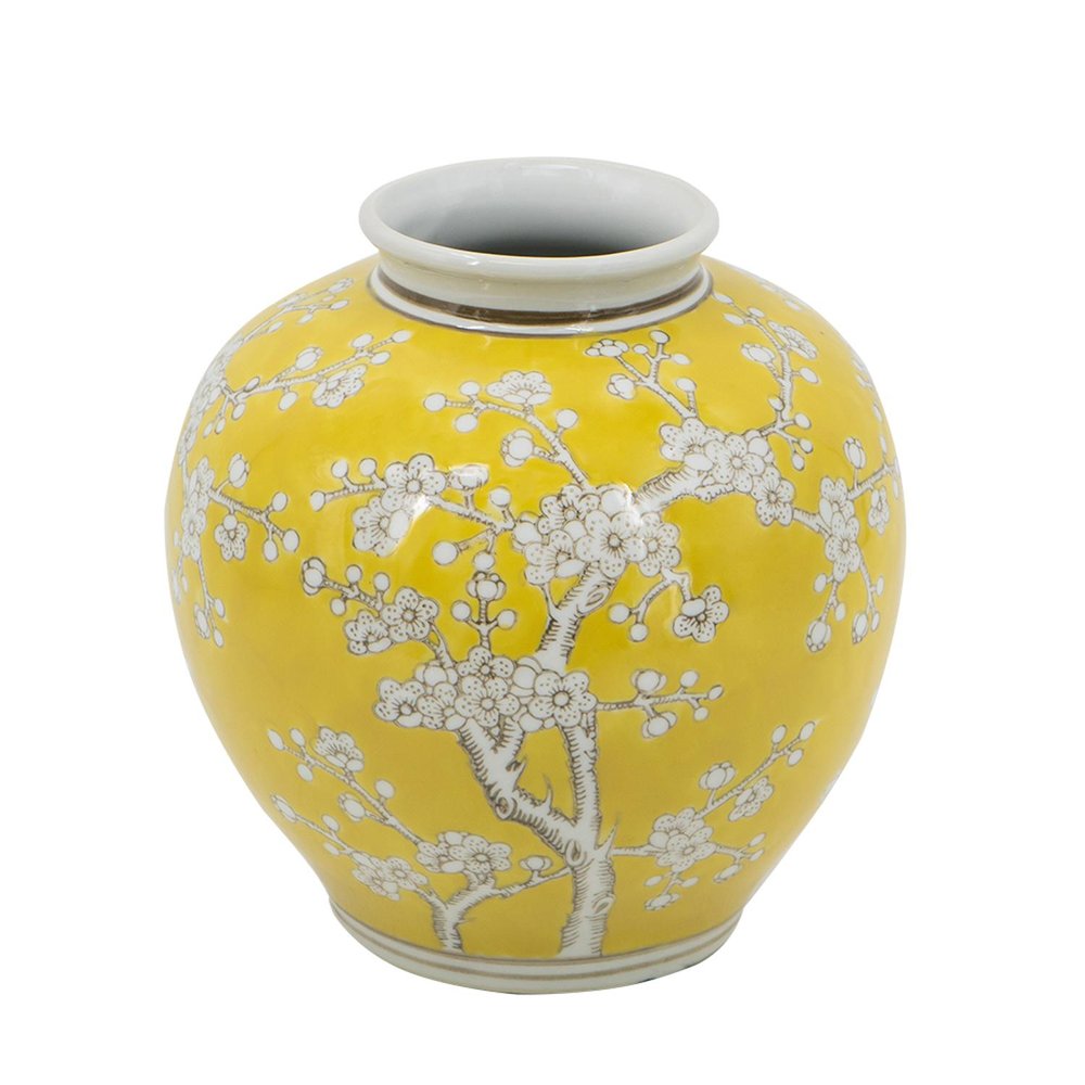 A yellow porcelain vase with white Chinoiserie floral design and a white interior, set against a white background.