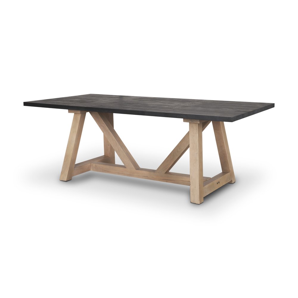 Black solid wood tabletop on a light brown solid wood trestle base dining table against a white background.