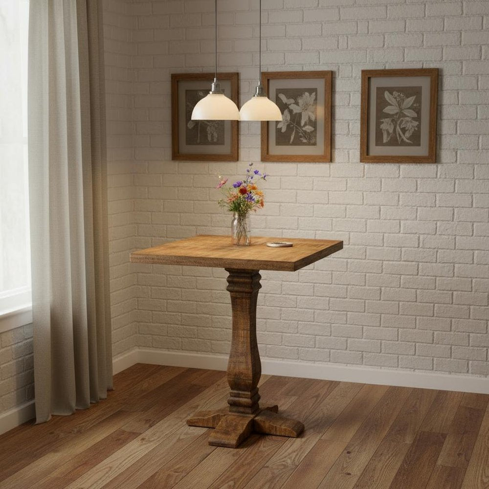36" Brown Solid Wood Square Pedestal Bar Table styled in a furnished interior with a tan wall on a dark wood floor.