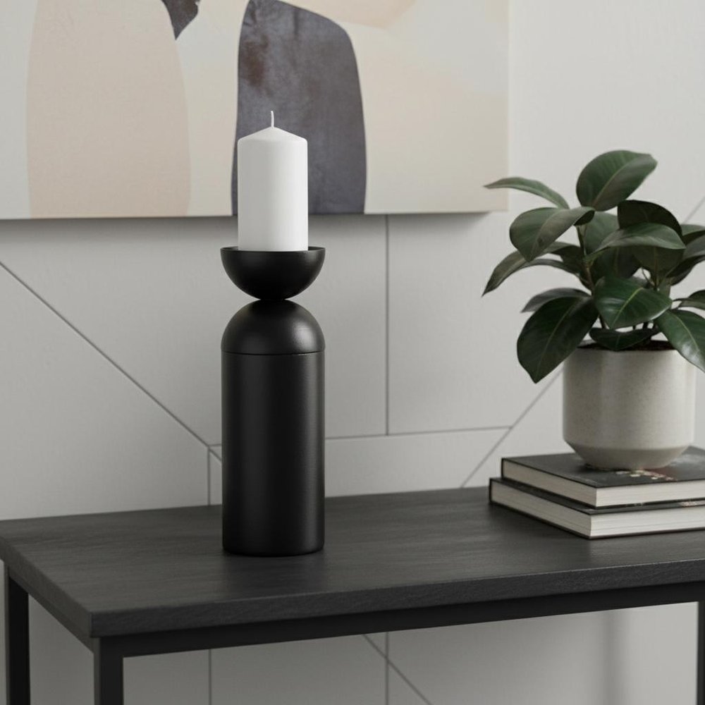 13" Black Metal Tabletop Pillar Candle Holder displayed on a tabletop in a furnished interior against an off-white wall.