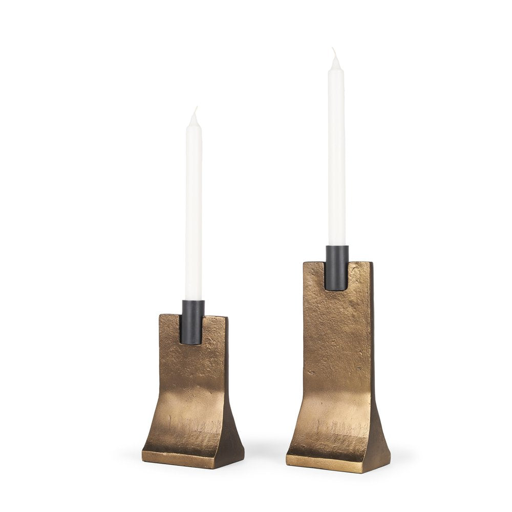 Two gold and black distressed hammered metal taper candle holders with white candles on a white background.