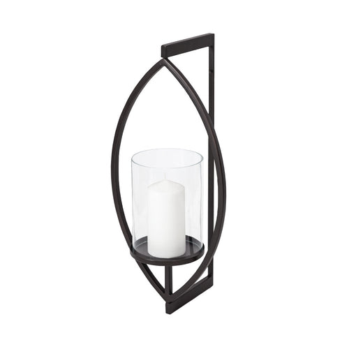 Black metal geometric wall lantern with a clear glass cylinder holding a white pillar candle against a white background.