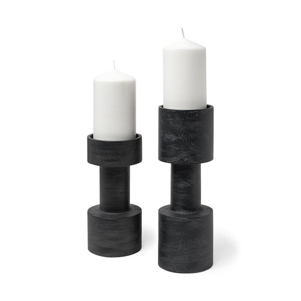 Two black distressed metal pillar candle holders with white pillar candles on a white background.