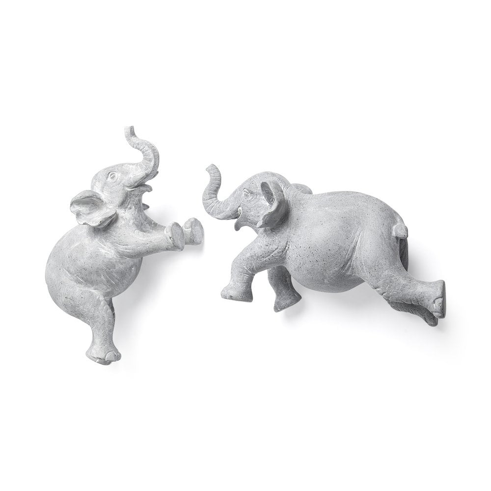 Two gray resin elephant sculptures hanging on a white background.