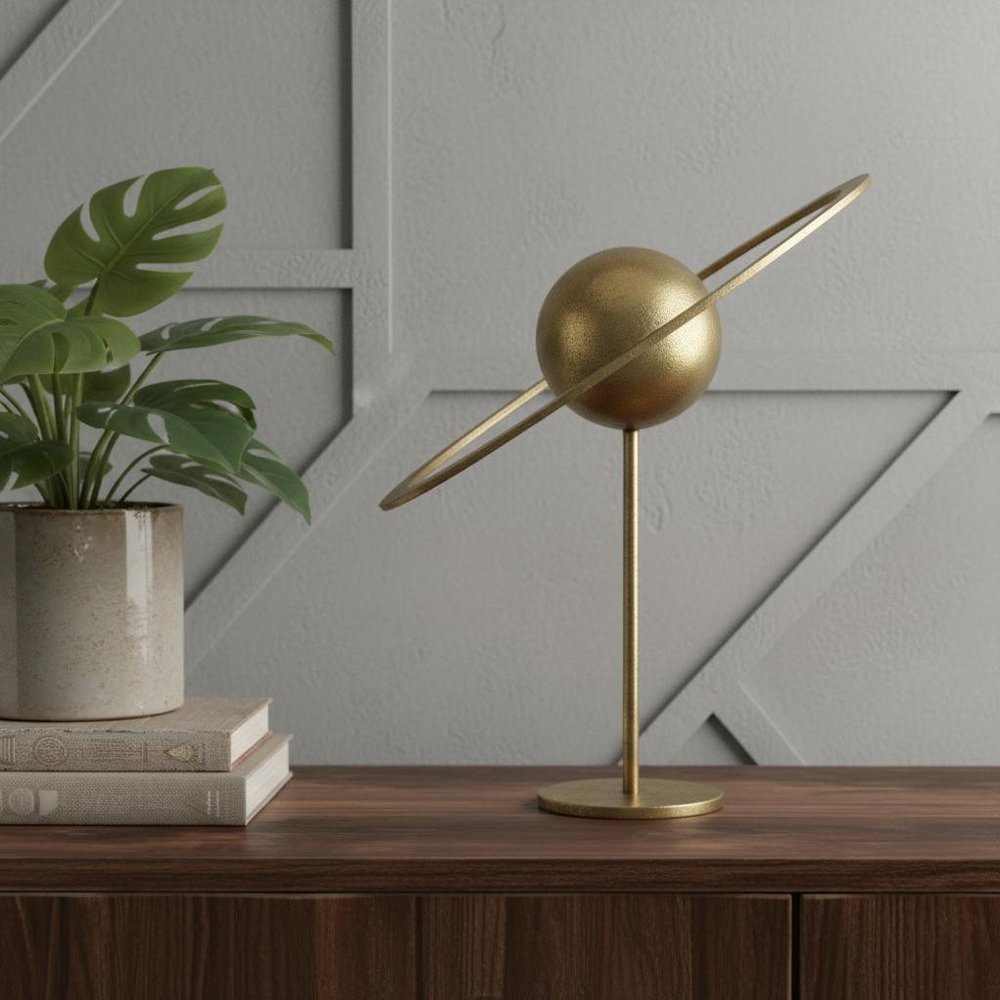 16" Gold Iron Solar System Tabletop Sculpture styled in a furnished interior with a gray wall on a dark wood floor.