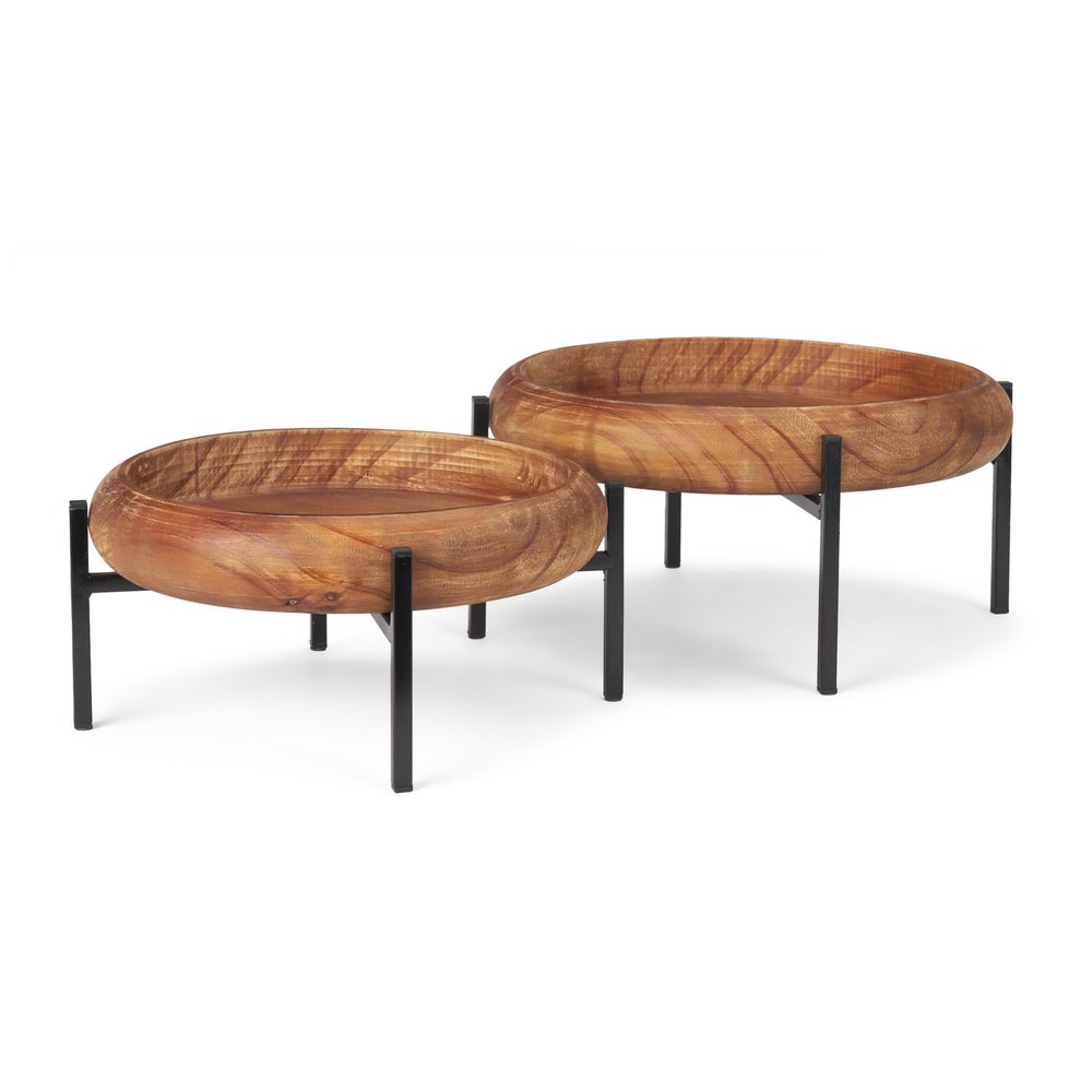 Set of two round brown solid wood serving trays with black metal stands on a white background.