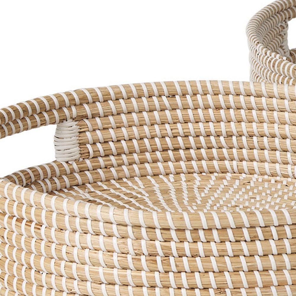 Close-up of a woven basket with natural straw and white stripe details, featuring handles.