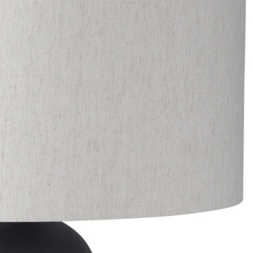 Cropped view of 30" Black Round Bedside Lamp With Drum Shade focusing on the black surface.