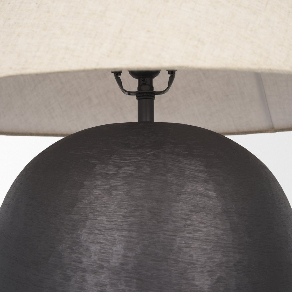 24" Black Round Bedside Lamp With Empire Shade styled in a furnished interior with a cream wall on a charcoal floor.