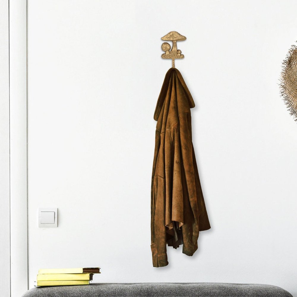 4" Gold Cast Iron Mushroom Wall Hook. Coat hanger isolated on a plain white background, showing a metal surface.