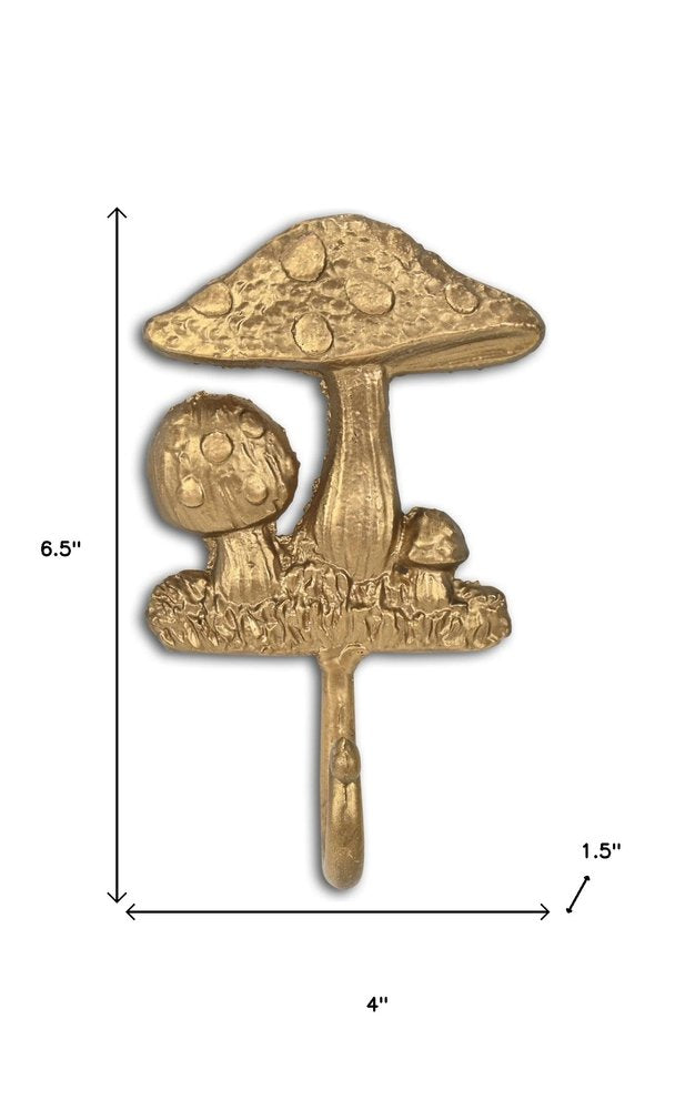 4" Gold Cast Iron Mushroom Wall Hook. Coat hanger isolated on a plain white background, finished in gold metal.