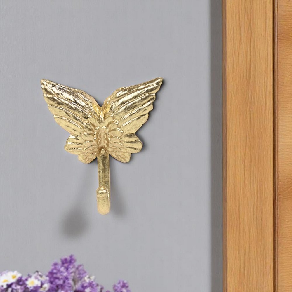 5" Gold Cast Iron Butterfly Wall Hook. Coat hanger isolated on a plain white background, showing a gold metal surface.