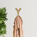 3" Gold Cast Iron Deer Stag Wall Hook shown outdoors on an outdoor setting with greenery.