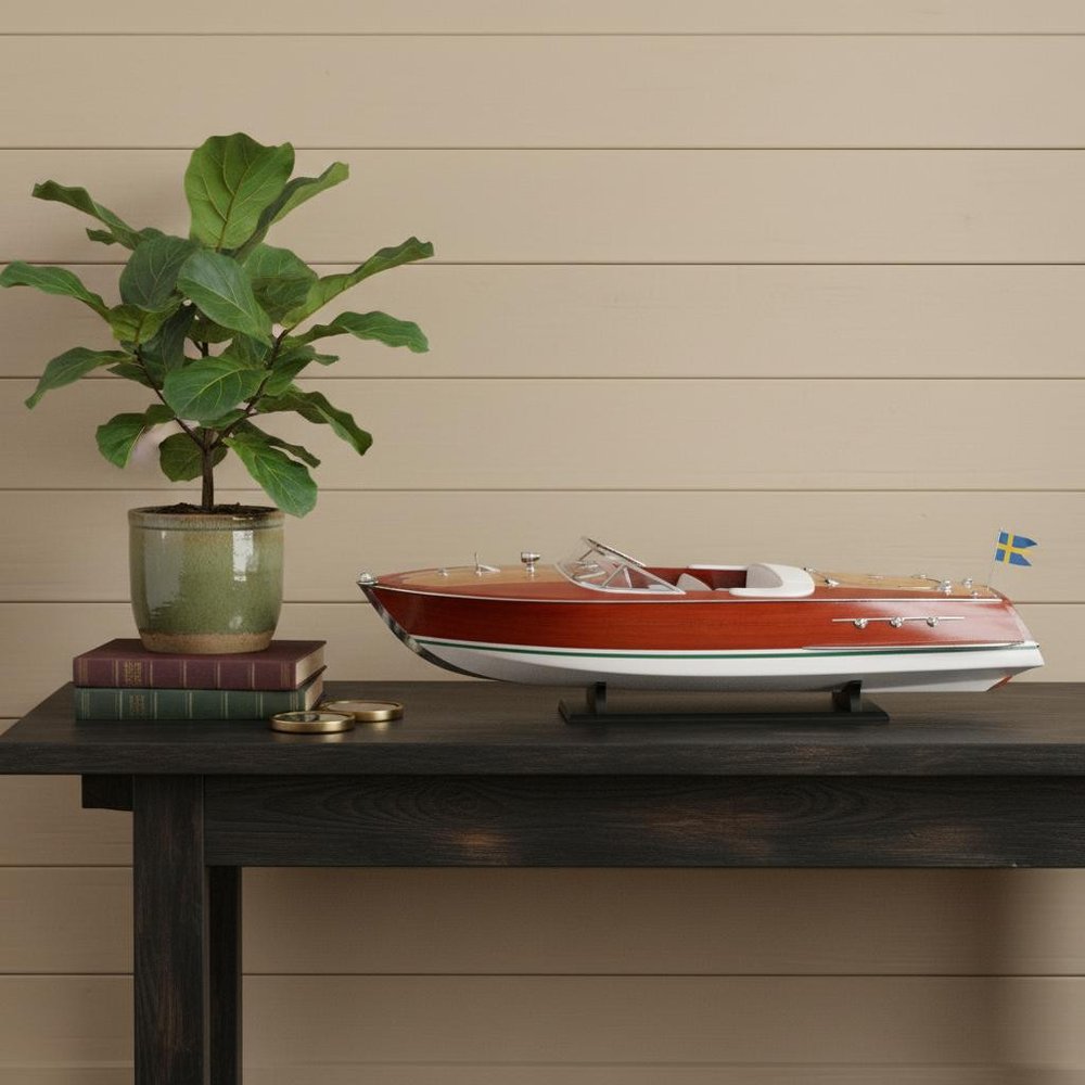 10" Unfinished Wood Hand Painted Model Boat styled in a furnished interior with a tan wall on a dark wood floor in tan wood.