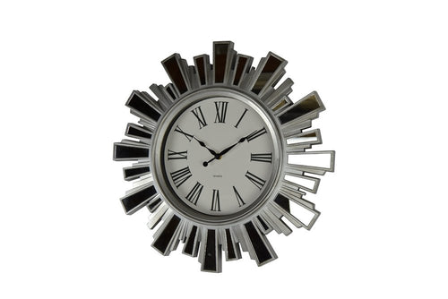 Silver and clear mirrored glass sunburst wall clock with Roman numerals on a white background.