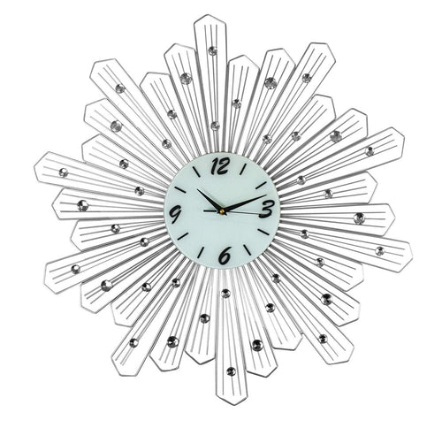 Silver and white metal sunburst wall clock with clear crystals on a white background.