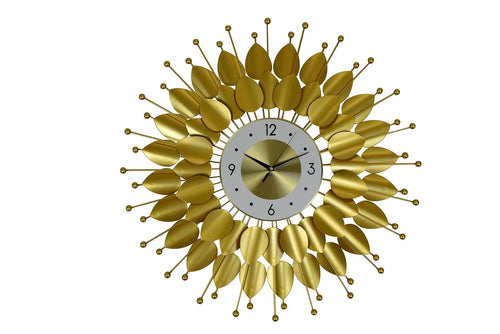 Gold and white metal analog floral sunburst wall clock on a white background.