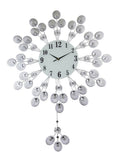 Silver and white metal starburst wall clock with a white face and black numbers, set against a white background.
