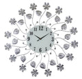 Silver and white metal and glass floral wall clock with black numbers and hands on a white background.