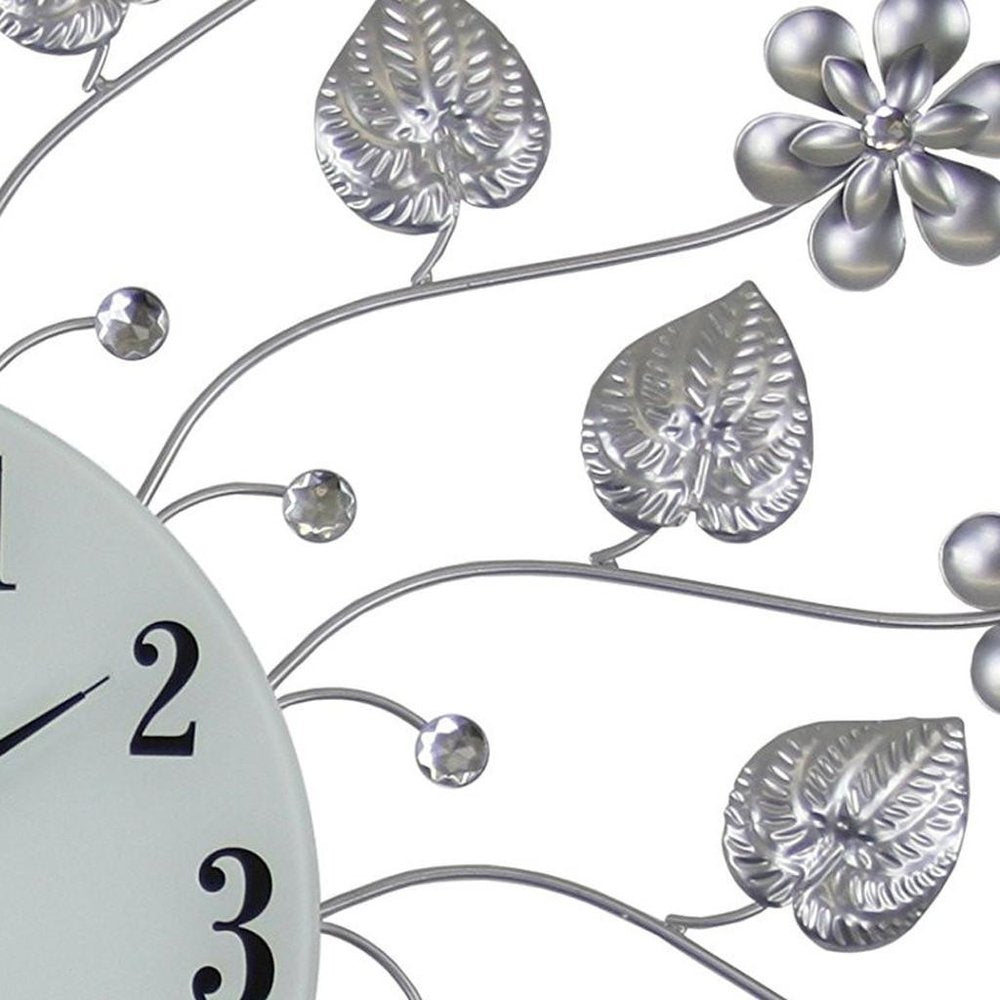 27" Silver White And Black Metal and Glass Silent Analog Floral Round Wall Clock. Wall clock isolated on a plain white background, showing a silver glass surface.