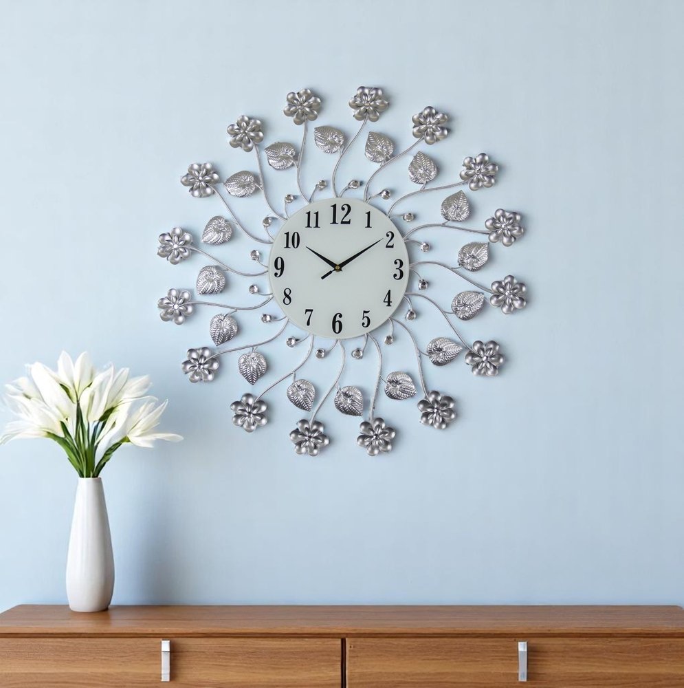 27" Silver White And Black Metal and Glass Silent Analog Floral Round Wall Clock shown outdoors on an outdoor setting.
