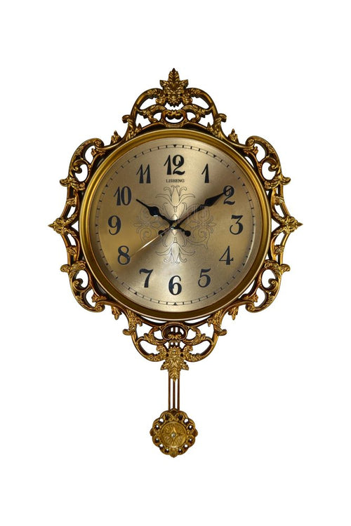Antique gold ornate wall clock with black numbers and pendulum, set against a white background.