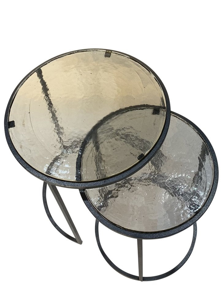 Set of Two Clear and Gunmetal Glass and Iron Round Frame Nested Tables on a white background