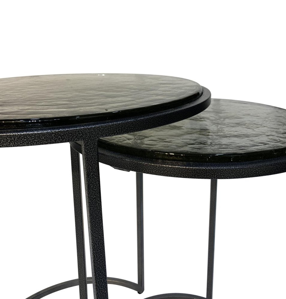 Set of Two Clear and Gunmetal Glass and Iron Round Frame Nested Tables on a white background