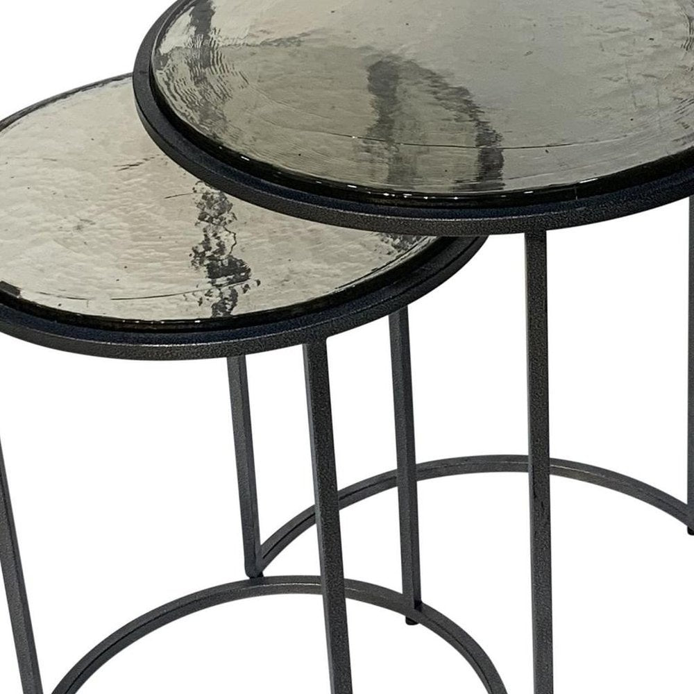 Set of Two Clear and Gunmetal Glass and Iron Round Frame Nested Tables on a white background