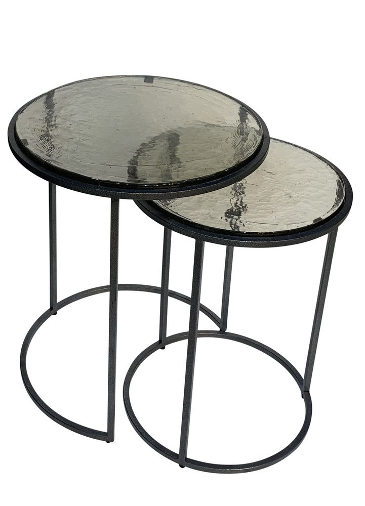 Set of Two Clear and Gunmetal Glass and Iron Round Frame Nested Tables on a white background