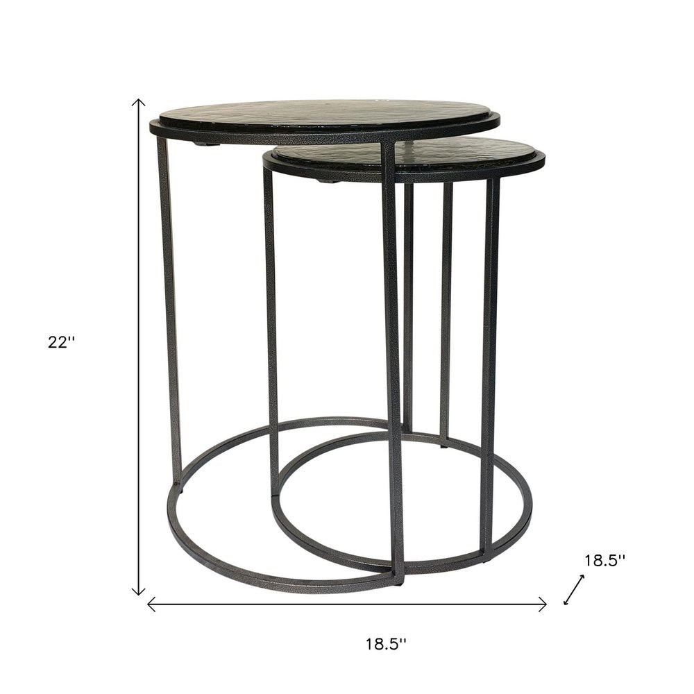 Set of Two Clear and Gunmetal Glass and Iron Round Frame Nested Tables on a white background