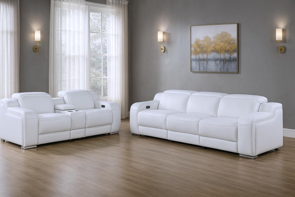 White leather five-person seating set with a sofa and loveseat in a room with sheer curtains and a painting.