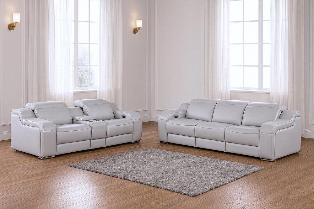 Two-piece light gray leather five-person seating set with a rug in a room with white curtains and wall sconces.