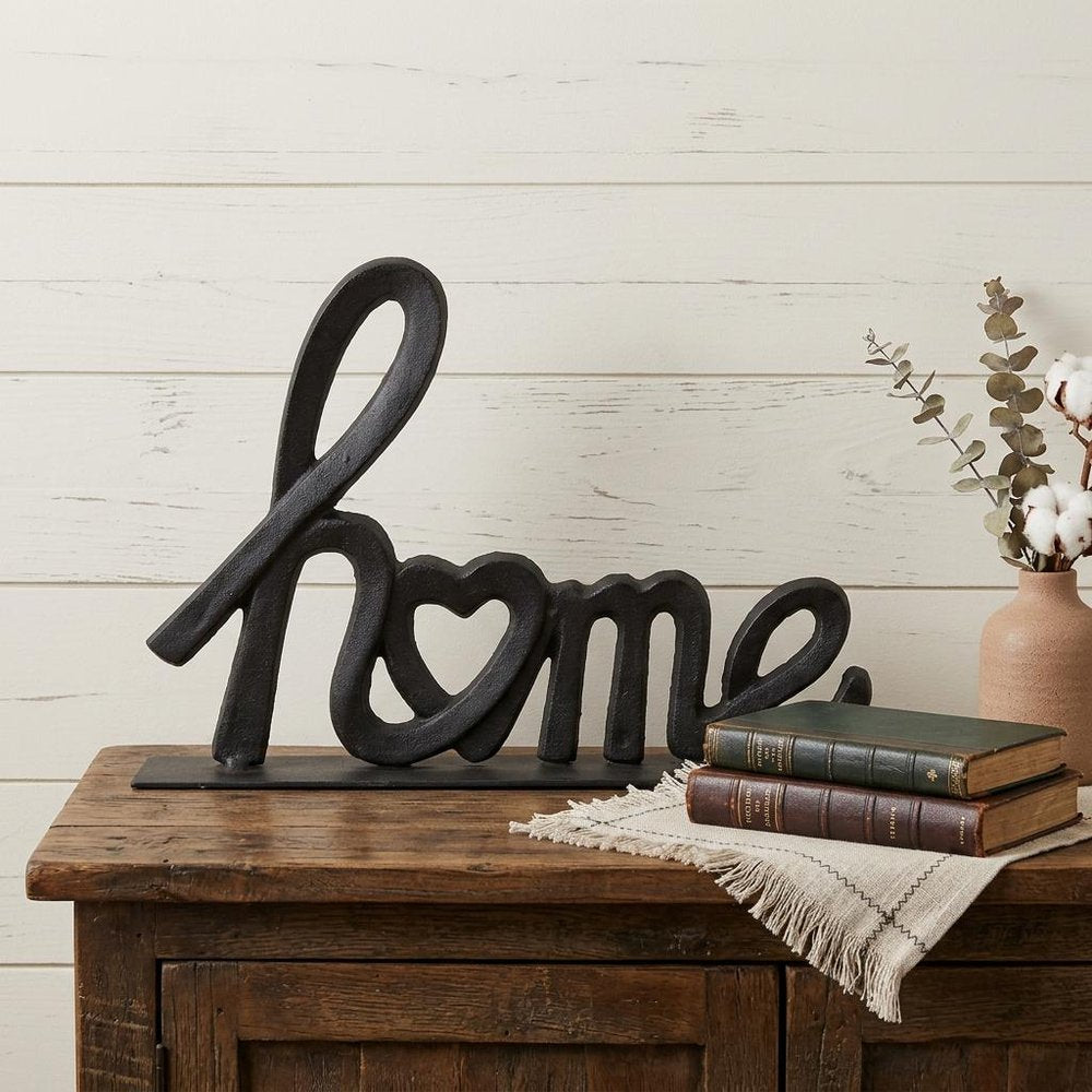 12" Black Cast Iron Home Hand Painted Tabletop Sculpture styled in a furnished interior with an off-white wall on a dark wood floor.