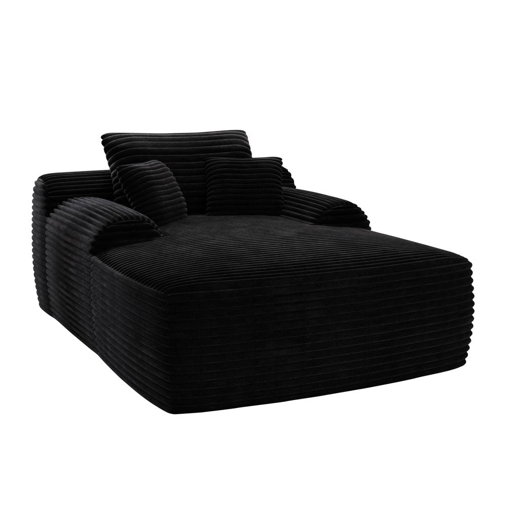 Black corduroy oversized chaise lounge chair with toss pillows on a white background.