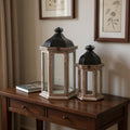Set of Two Brown Distressed Geometric Metal And Solid Wood Floor Lantern Candle Holders in a home interior