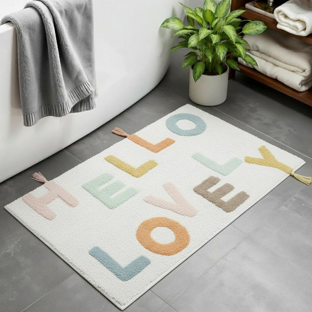 32" Blue White And Yellow Cotton Hello Lovely Youthful Bath Rug laid on a tiled floor in a furnished interior.