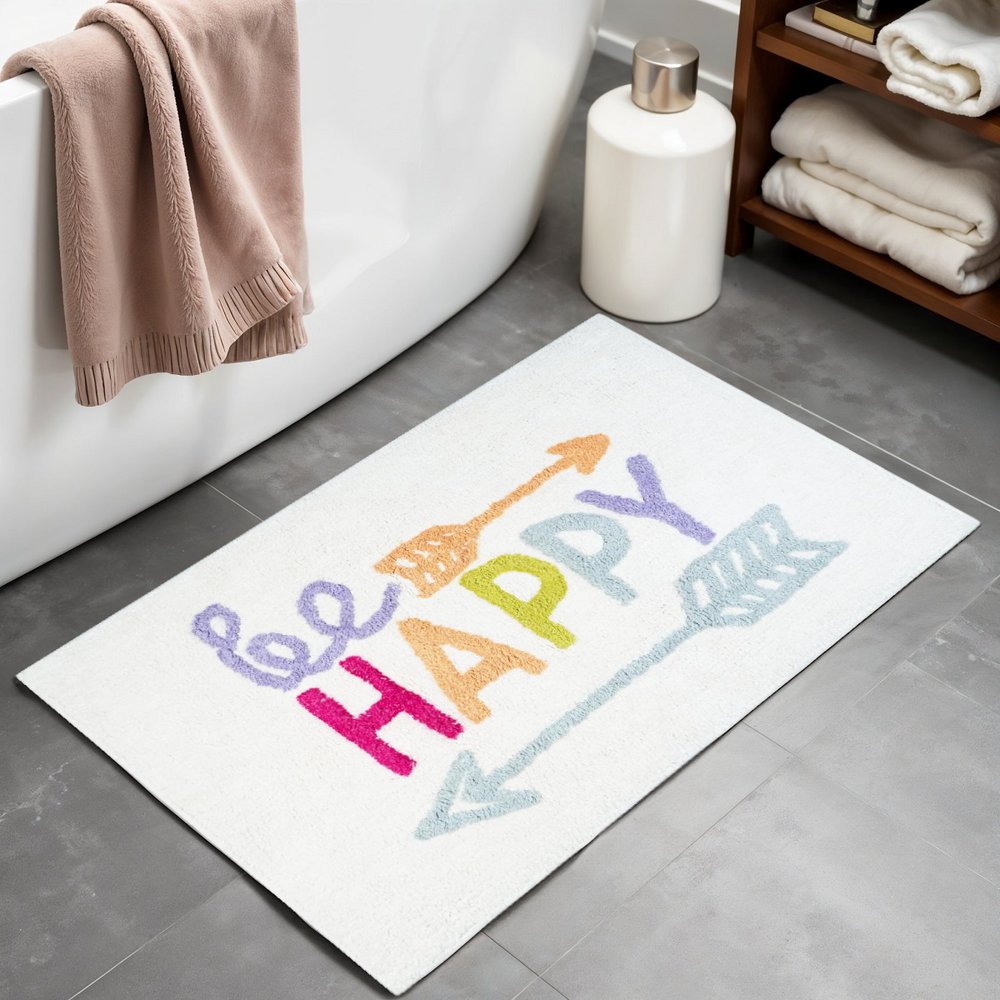 32" White Purple And Green Cotton Be Happy Youthful Bath Rug laid on a tiled floor in a furnished interior.