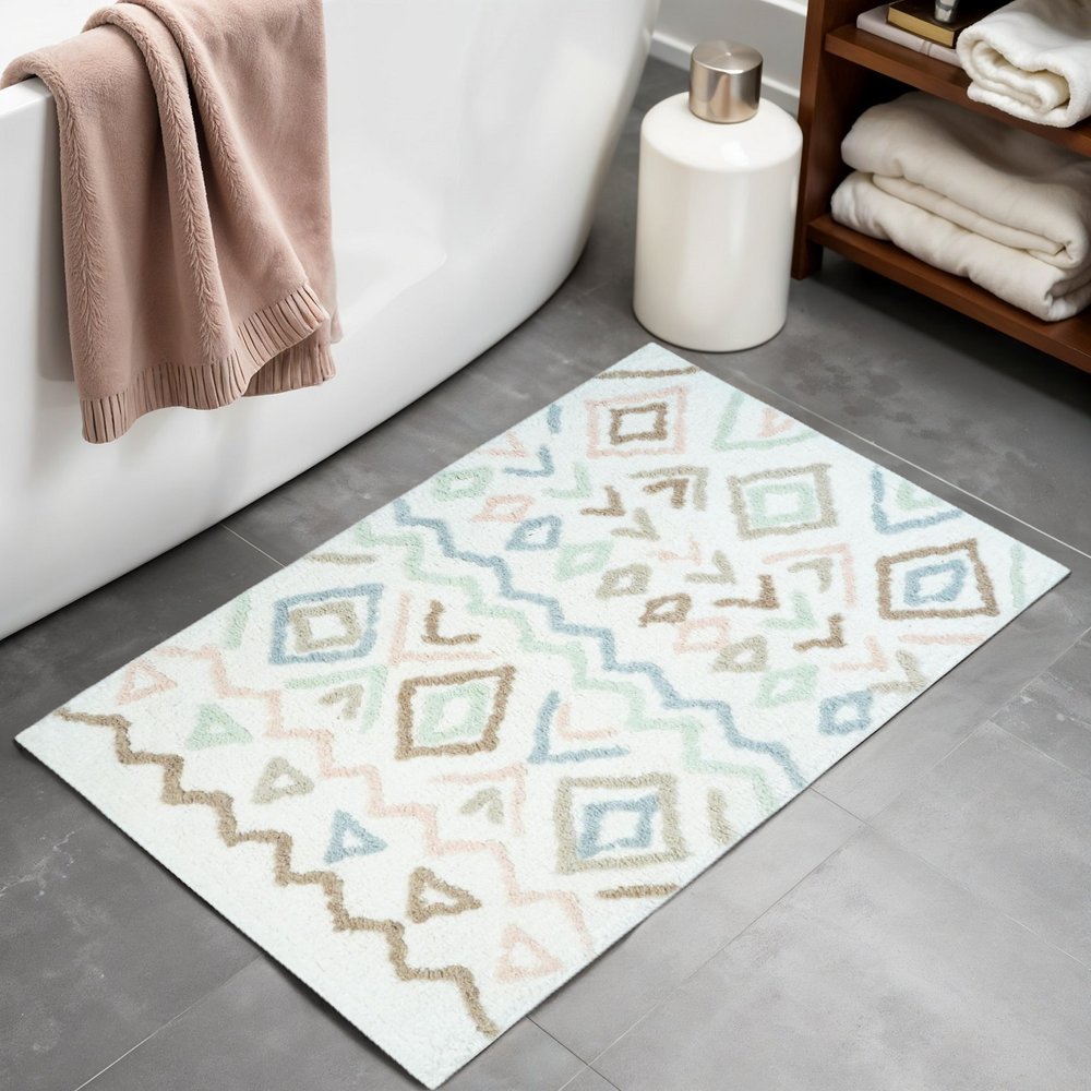32" Blue Brown And White Cotton Geometric Bath Rug laid on a tiled floor in a furnished interior.