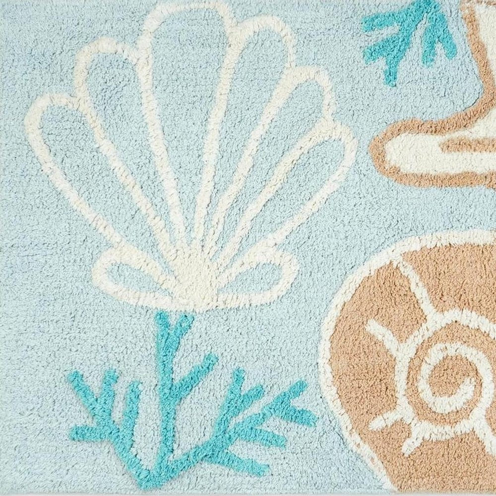 32" Blue Tan And White Cotton Seashells And Coral Bath Rug. Bath rug isolated on a plain white background, showing a white cotton surface.