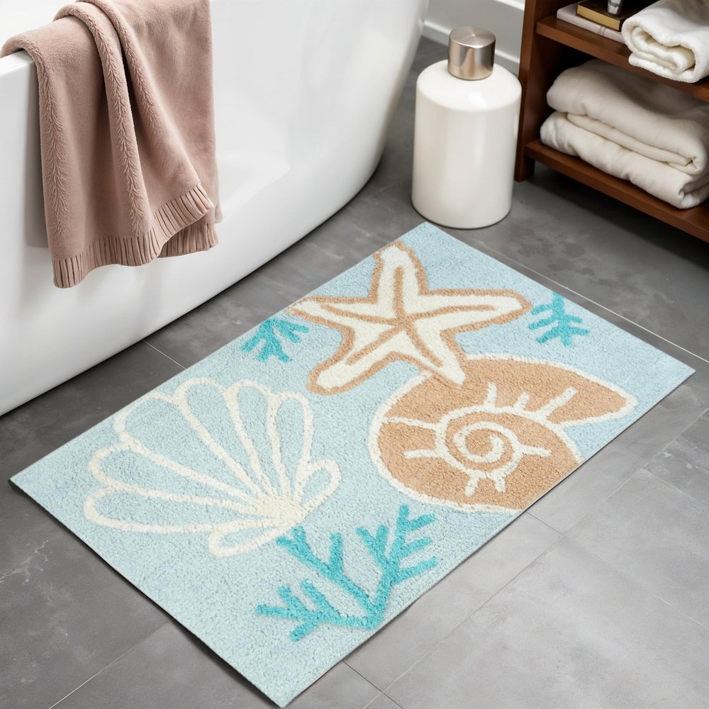 32" Blue Tan And White Cotton Seashells And Coral Bath Rug laid on a tiled floor in a furnished interior.